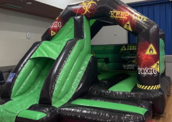 Black and green inflatable side with decorative 'Keep out' and 'Toxic' imagery, in Ardrossan Civic Centre hall