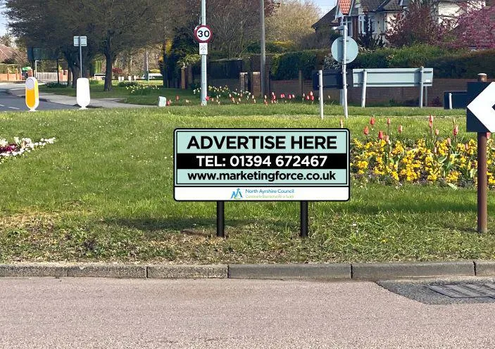 Roundabout containing Advertise Here sign with phone number, NAC logo, Marketing Force website.