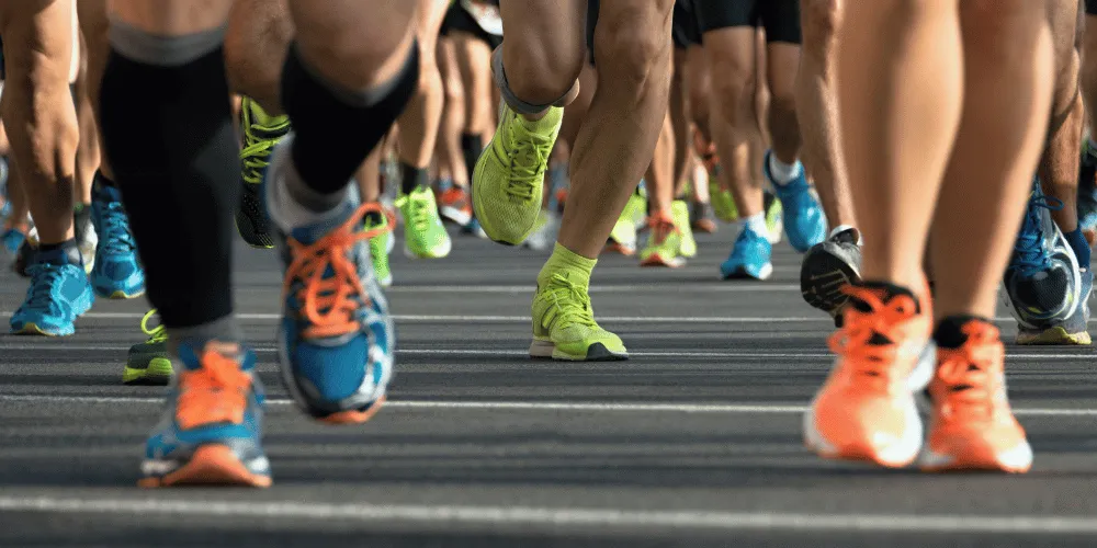 A group of runners' feet with colourful running shoes