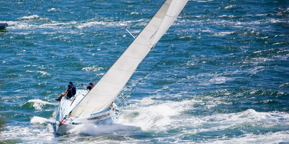 A sailboat riding on sea waves.