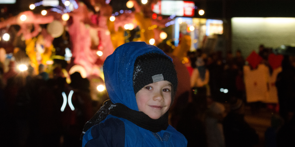 Child smiling in front of a light parade