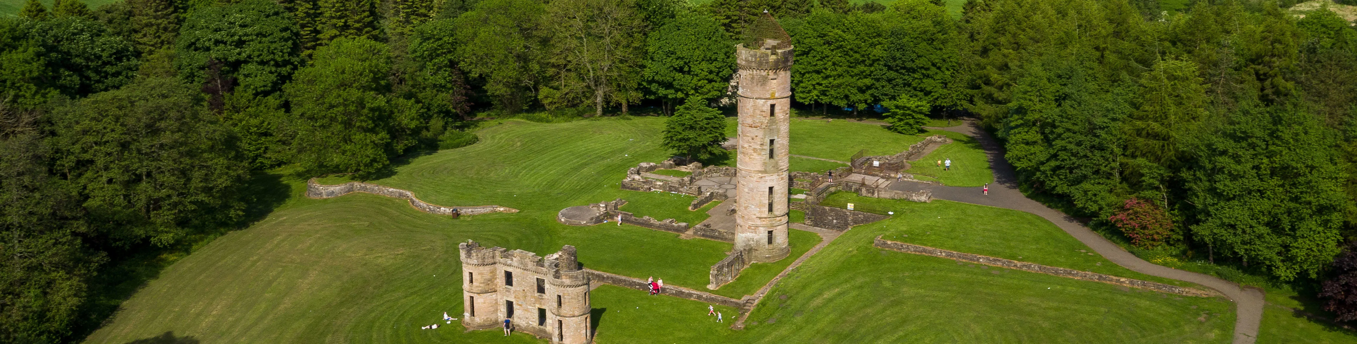 Aerial view of Eglinton castle ruins surrounded by trees 